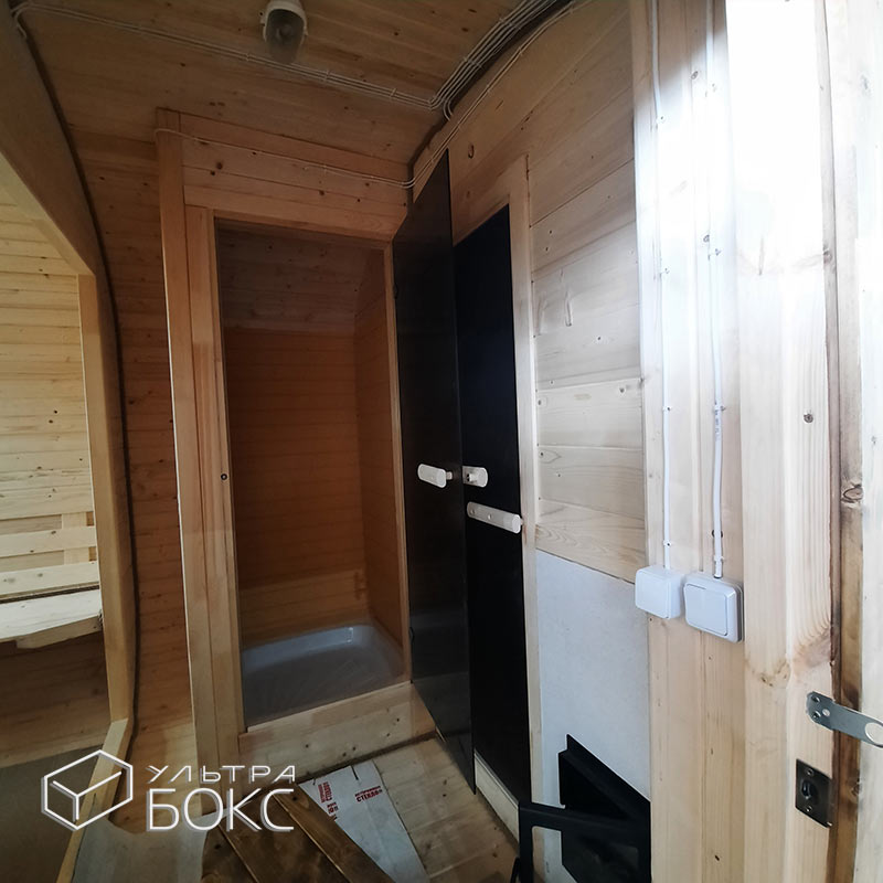 Квадро-Баня 6х2,6х2,4 м +ДОПЫ: увеличенная 2,6 м / ширина стен 2,4 м, деревянный козырёк с мягкой кровлей над входом, дверь внутренняя стеклянная, окно ПВХ полукругло, спинка деревянная под лавочку, душевой поддон для помывочного отделения, печь на дровах «Везувий Лава», деревянное ограждение вокруг печи — изображение 10